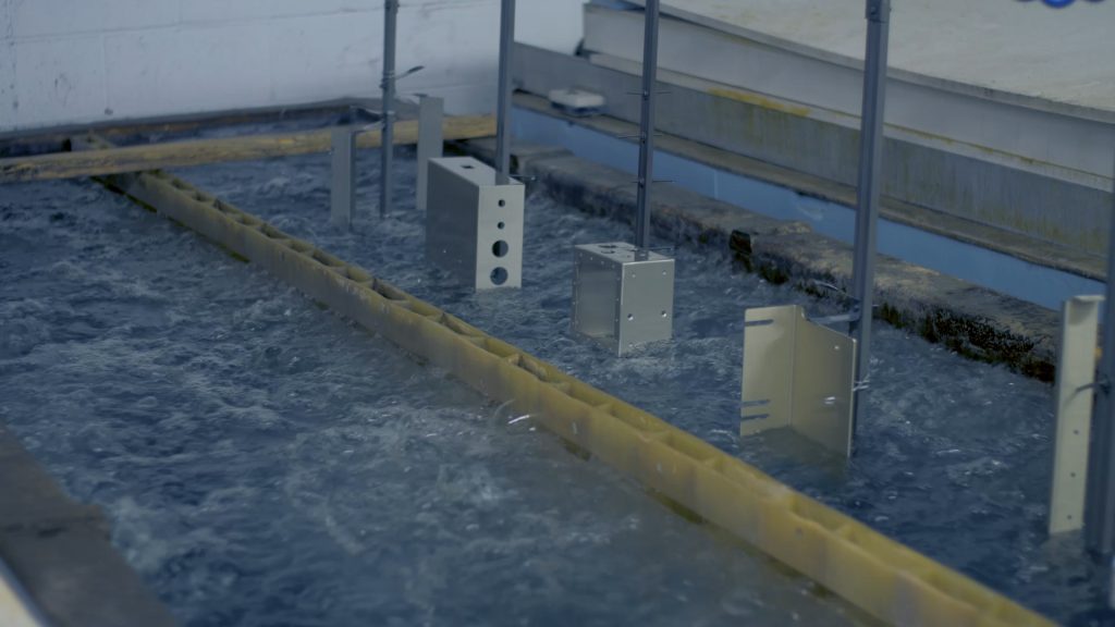 Aluminium parts suspended on racks and submerged in an anodizing tank during the electrochemical oxidation process