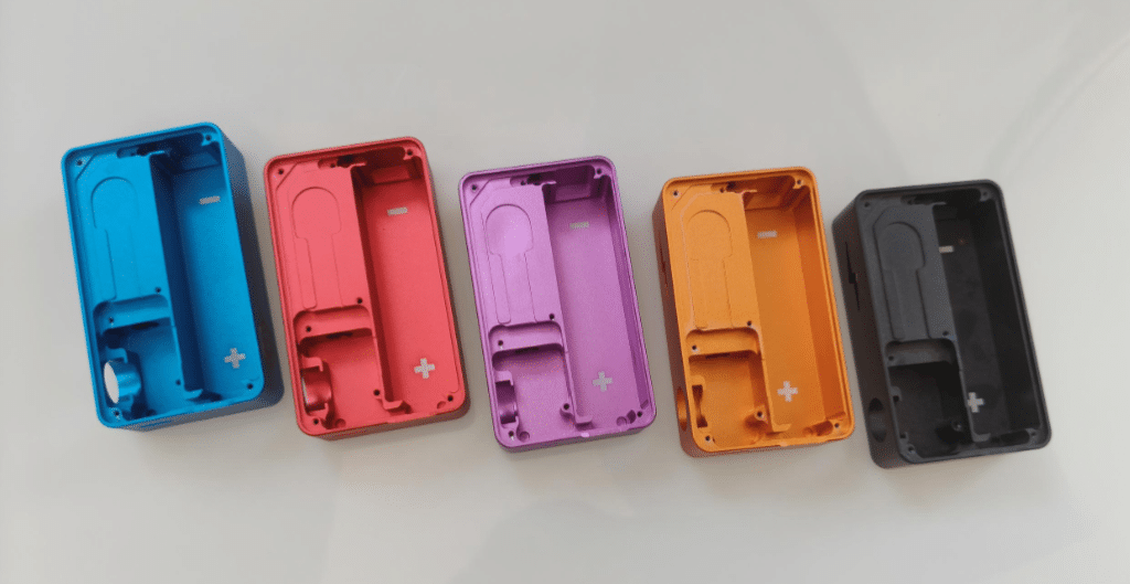 Machined aluminum housings with pockets anodized in cyan, pink, purple, orange, and black