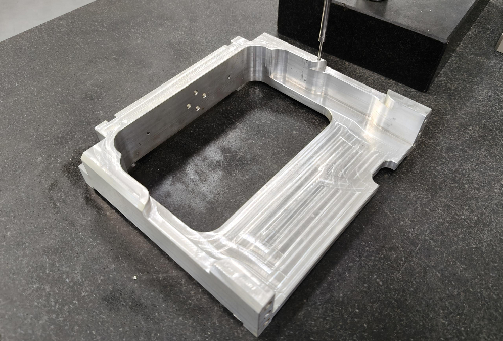 CNC end milled aluminum part with a machined rectangular pocket and stepped side walls