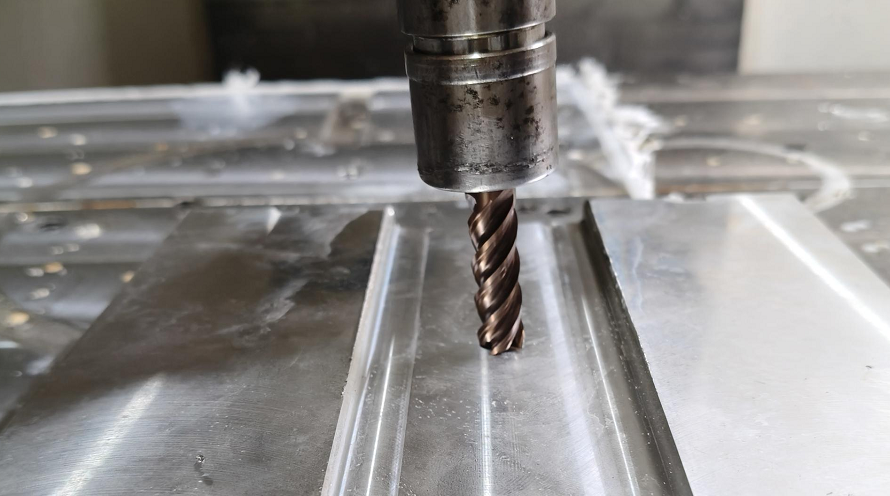 End mill cutting a slot into a metal workpiece during the CNC end milling process